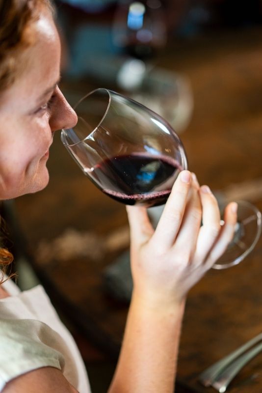 Guest smelling a glass of red wine during a wine tasting at the Jones Winery & Vineyard cellar door in Rutherglen, Victoria.